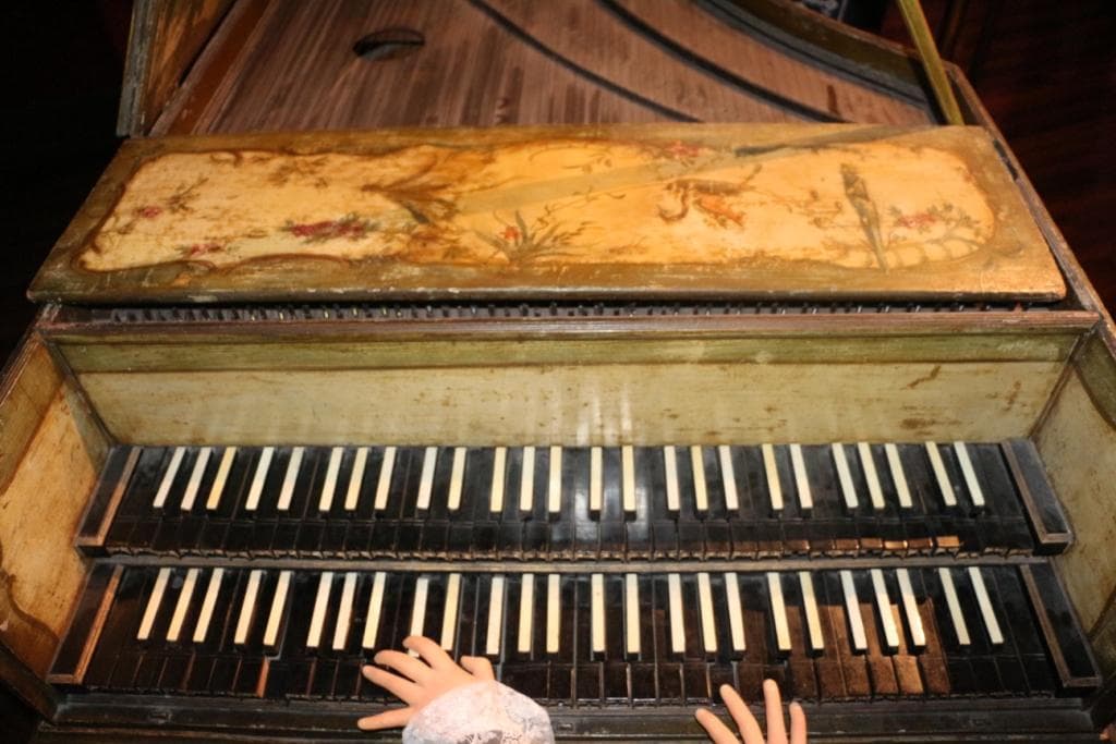 “Clavecin du XVIIIe siècle en bois sculpté et polychrome, témoin de l’histoire musicale au Musée Grevin”