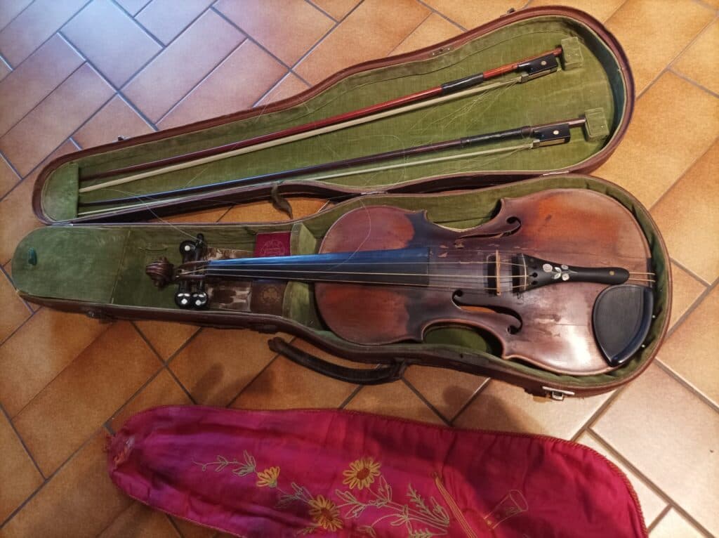 Ancien violon de la prestigieuse famille Guadagnini accompagné de deux archets et de colophane d’origine malgré une légère fissure sur la face avant